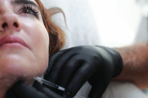 Zbliżenie zabiegu medycyny estetycznej twarzy wykonywanego w klinice